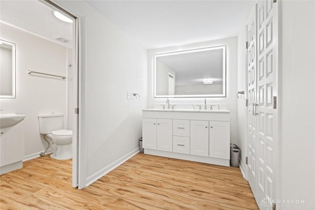 bathroom featuring hardwood / wood-style flooring, vanity, and toilet