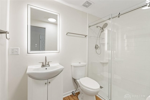 bathroom with vanity, toilet, an enclosed shower, and hardwood / wood-style floors