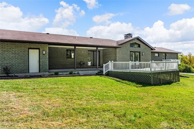 back of house with a wooden deck and a yard