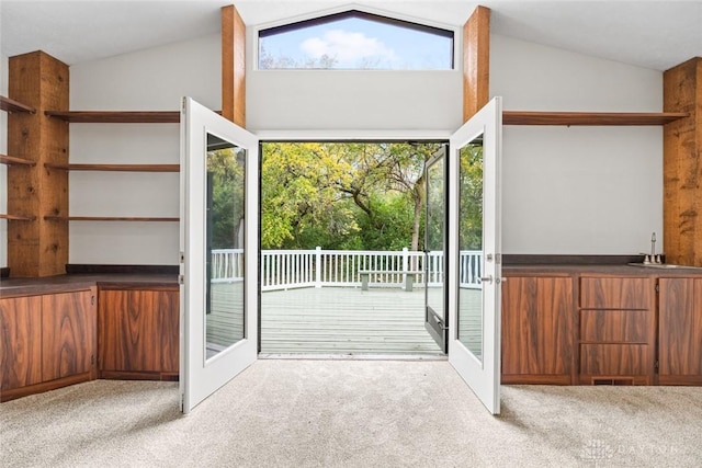 doorway featuring lofted ceiling, sink, light colored carpet, and french doors