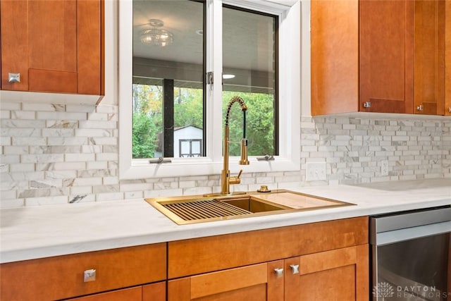 kitchen with tasteful backsplash, sink, and dishwashing machine