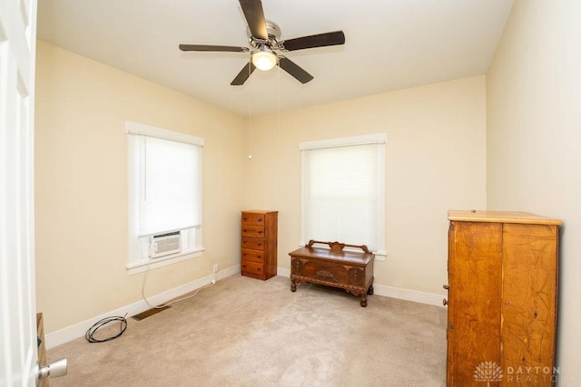 interior space featuring ceiling fan, light colored carpet, and cooling unit