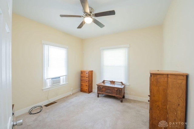 interior space with ceiling fan, cooling unit, and light colored carpet