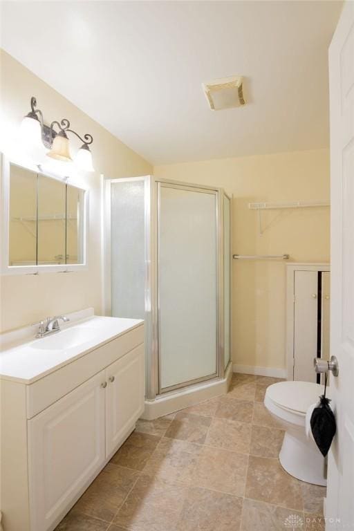 bathroom with an enclosed shower, vanity, and toilet