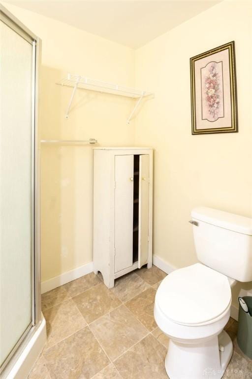 bathroom featuring toilet and an enclosed shower