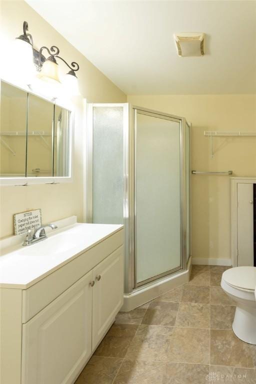 bathroom with toilet, an enclosed shower, and vanity