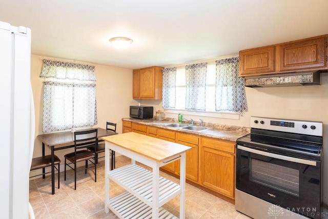 kitchen featuring sink, white fridge, custom range hood, and electric stove