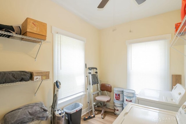 clothes washing area featuring ceiling fan, light hardwood / wood-style flooring, and washer and dryer