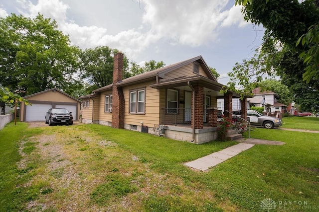 view of front of property with a porch, a garage, an outbuilding, and a front yard