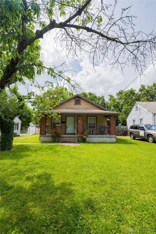 bungalow-style house with covered porch and a front lawn