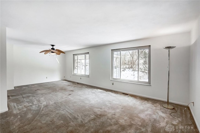 spare room featuring dark carpet and ceiling fan