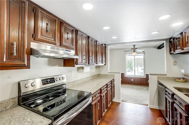 kitchen with light stone countertops, appliances with stainless steel finishes, dark wood-type flooring, and ceiling fan