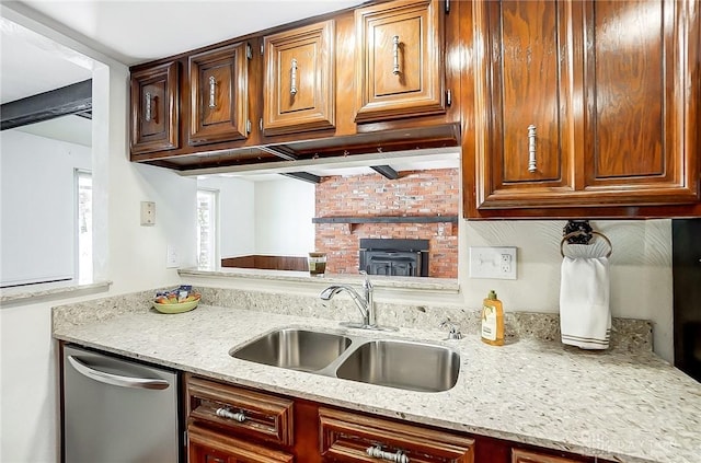 kitchen featuring sink, stainless steel dishwasher, and light stone counters