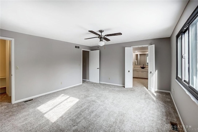 unfurnished bedroom with ceiling fan, light colored carpet, and multiple windows