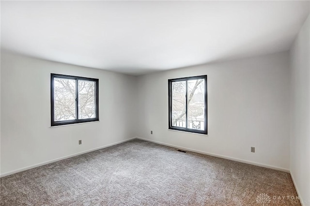 carpeted empty room featuring a healthy amount of sunlight