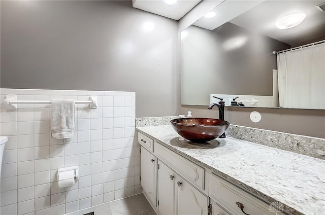 bathroom featuring vanity and tile walls