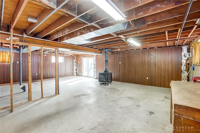 basement with wooden walls and a wood stove