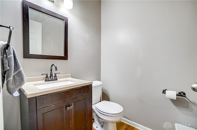 bathroom with vanity, toilet, and wood-type flooring