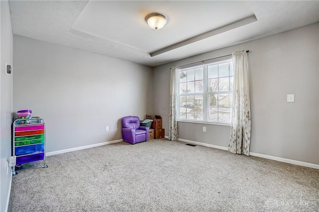 game room featuring light colored carpet and a tray ceiling