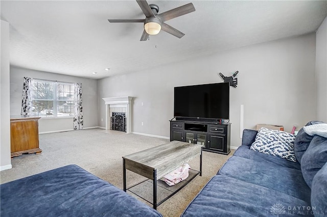 living room with ceiling fan, light colored carpet, and a fireplace