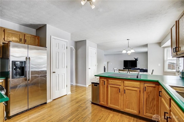 kitchen featuring decorative light fixtures, stainless steel fridge with ice dispenser, light hardwood / wood-style flooring, a textured ceiling, and a notable chandelier