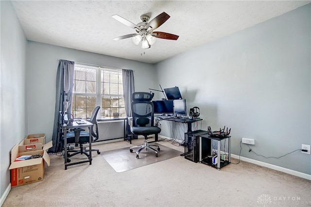 carpeted office space featuring ceiling fan and a textured ceiling