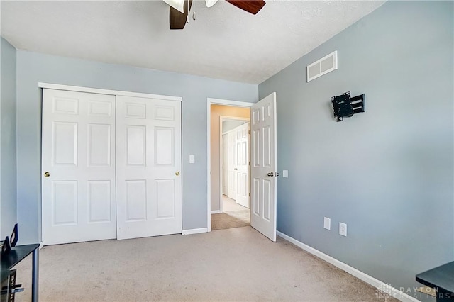 bedroom with ceiling fan, light colored carpet, and a closet