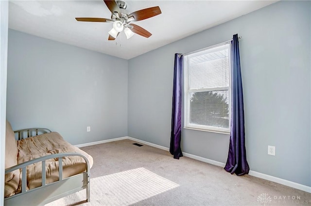 living area with light carpet and ceiling fan