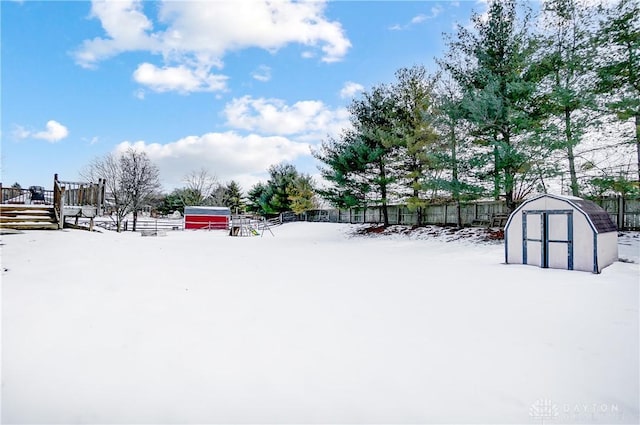 yard covered in snow with a storage unit