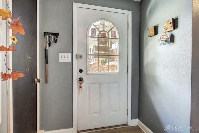 doorway to outside featuring plenty of natural light and baseboards