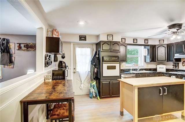 kitchen featuring wooden counters, dark brown cabinets, oven, dishwasher, and under cabinet range hood