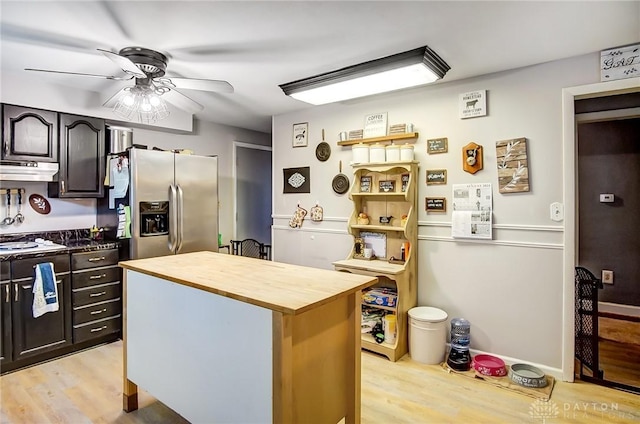 kitchen with dark brown cabinetry, a ceiling fan, stainless steel fridge with ice dispenser, light wood-style flooring, and under cabinet range hood