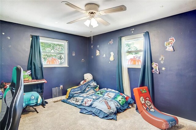 bedroom with multiple windows, ceiling fan, and carpet