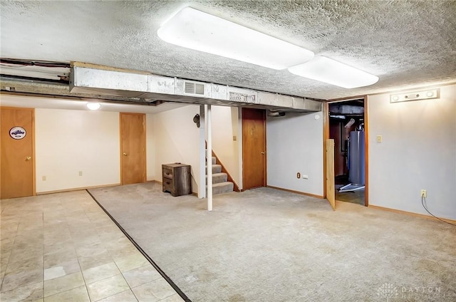 finished below grade area featuring water heater, stairway, a textured ceiling, and carpet flooring