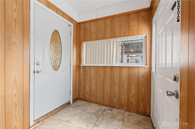 entryway featuring crown molding and wood walls