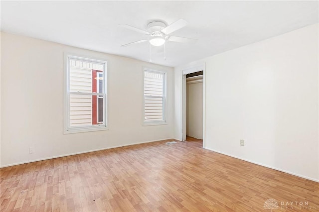 unfurnished bedroom with light wood-style flooring, ceiling fan, and a closet