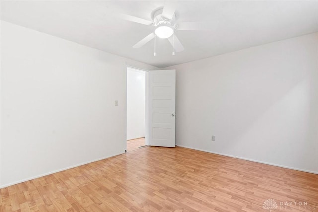 empty room featuring light wood-style floors, ceiling fan, and baseboards