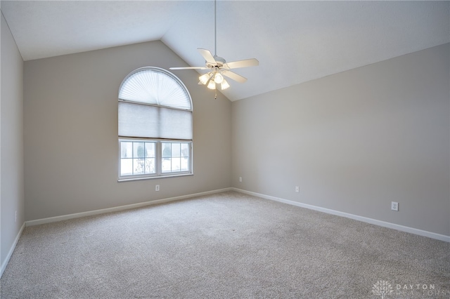 carpeted empty room with ceiling fan, vaulted ceiling, and a healthy amount of sunlight