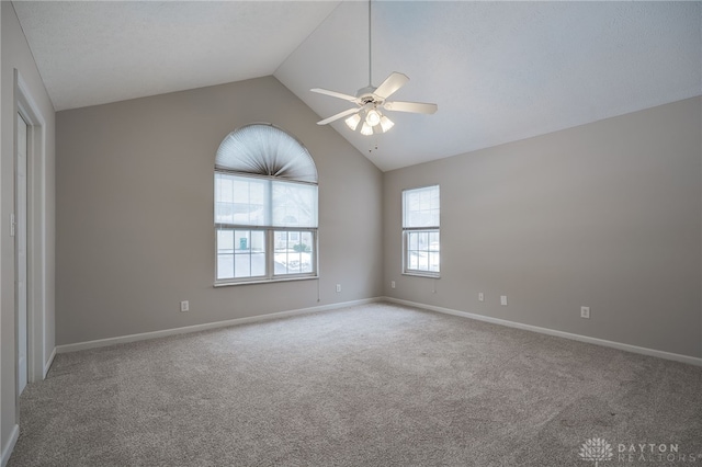 empty room with lofted ceiling, carpet flooring, and ceiling fan