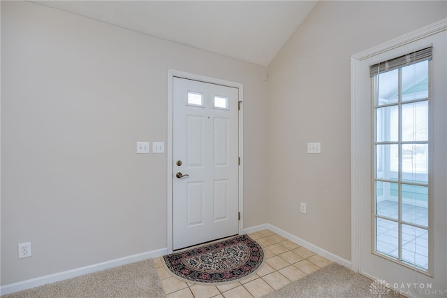 carpeted entryway featuring vaulted ceiling