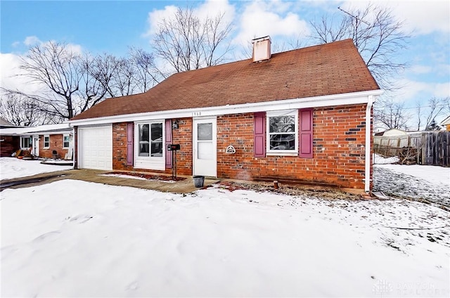 snow covered property featuring a garage