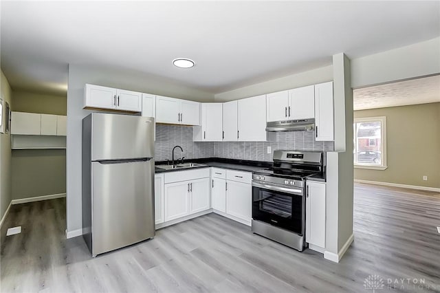 kitchen featuring sink, light wood-type flooring, stainless steel appliances, decorative backsplash, and white cabinets