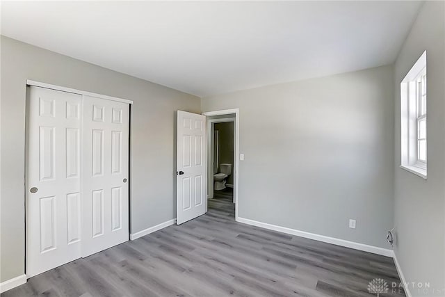 unfurnished bedroom featuring hardwood / wood-style floors and a closet