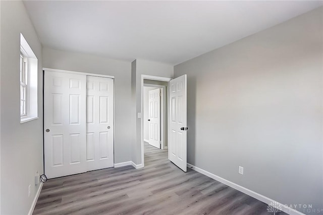 unfurnished bedroom featuring a closet and light wood-type flooring