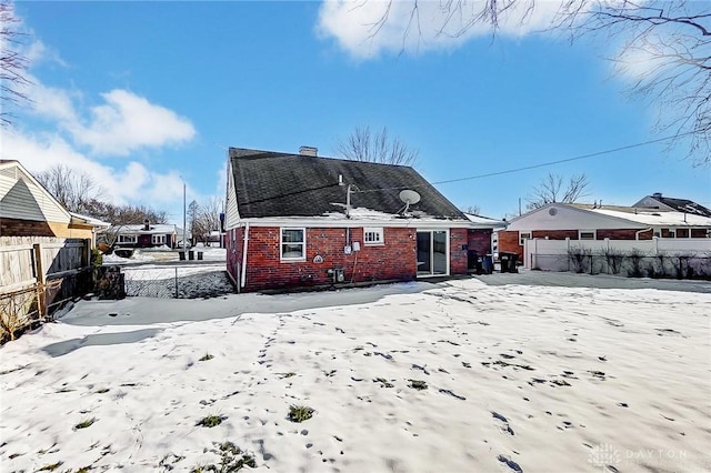 view of snow covered back of property