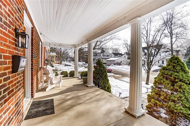 snow covered patio featuring a residential view