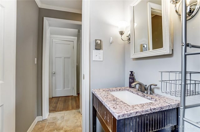 bathroom featuring ornamental molding, vanity, and baseboards