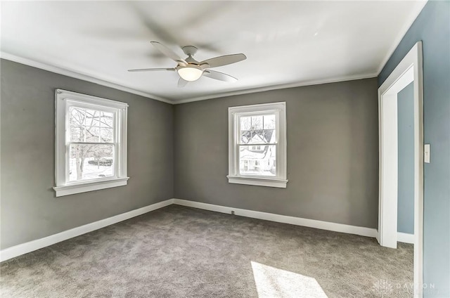 unfurnished room with baseboards, ornamental molding, a ceiling fan, and light colored carpet