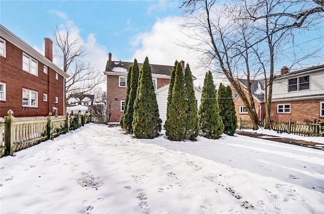 exterior space with a residential view, brick siding, and fence