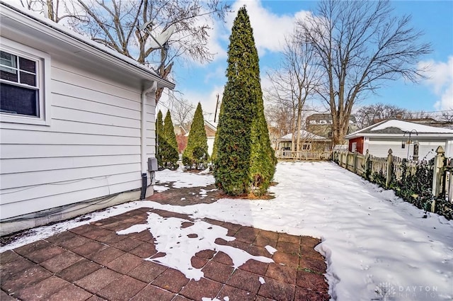 snow covered patio featuring fence